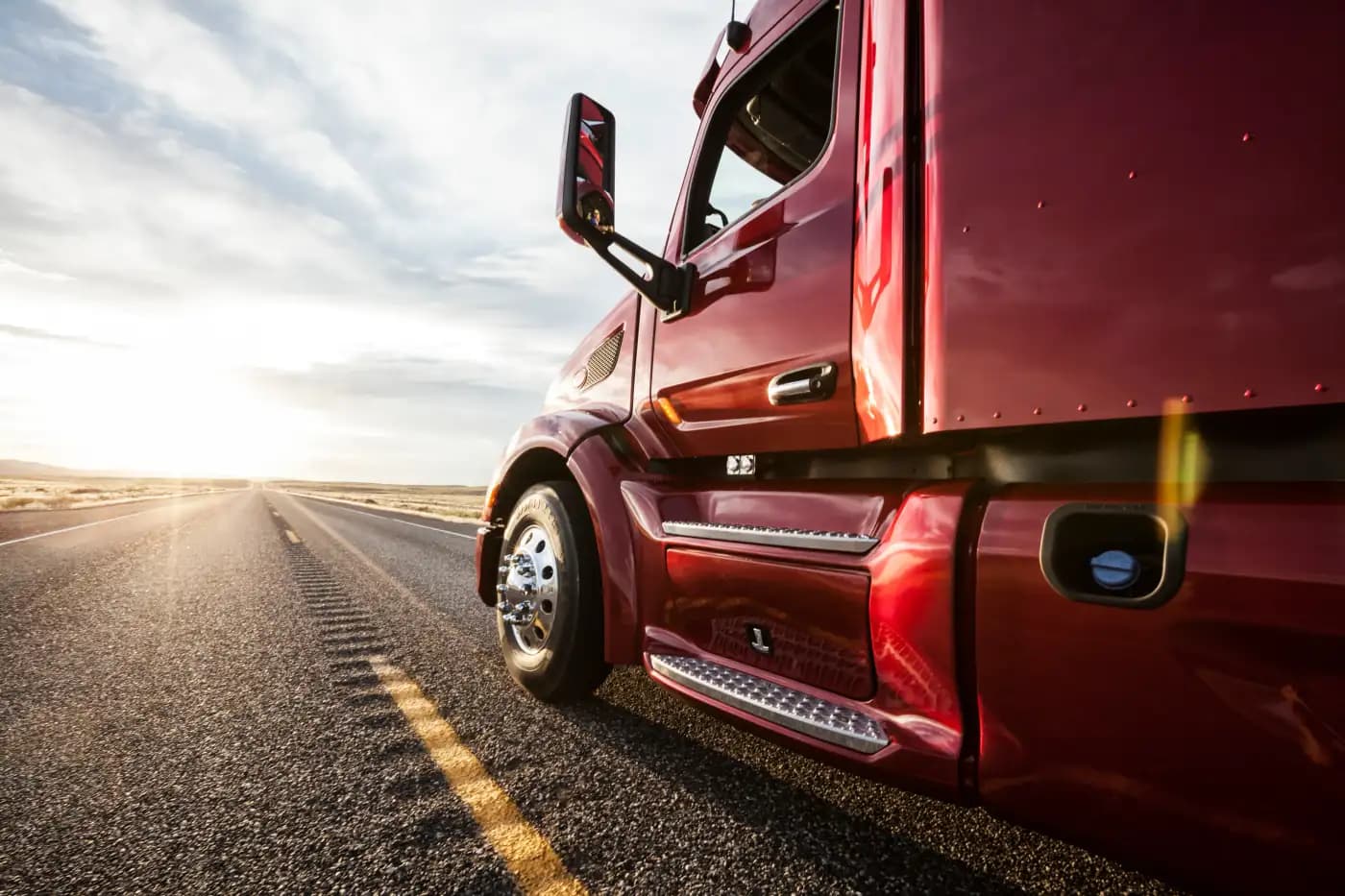 Side of a red semi-truck at sunset