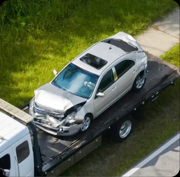 Damaged silver car on a tow truck