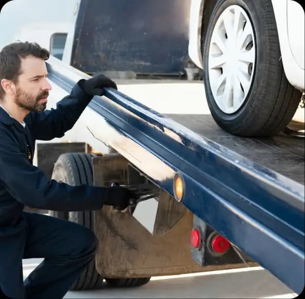 Worker securing a car on a tow truck