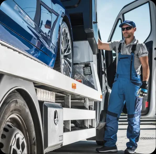 Worker standing beside a loaded recovery truck