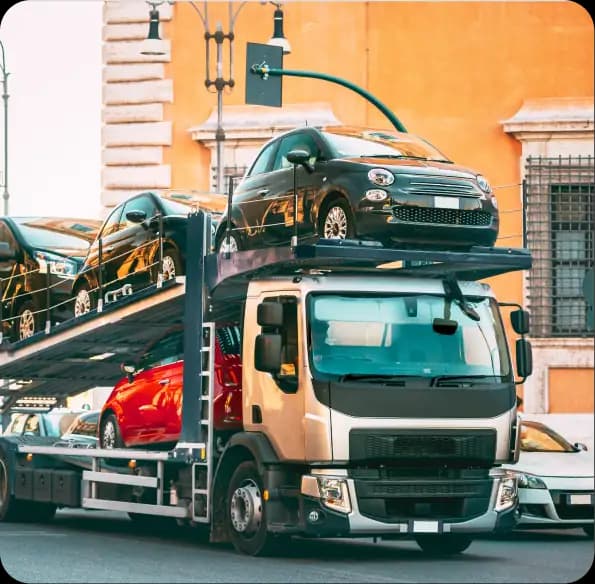 Open car carrier transporting cars along a city street