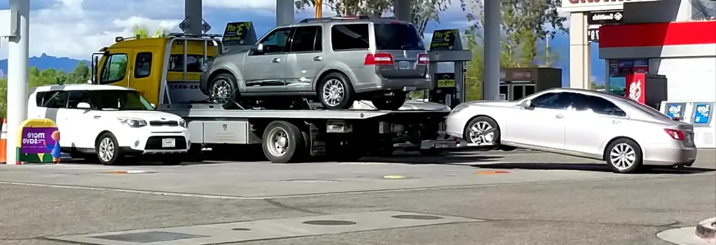 Vehicles loaded on a car carrier at a roadside stop