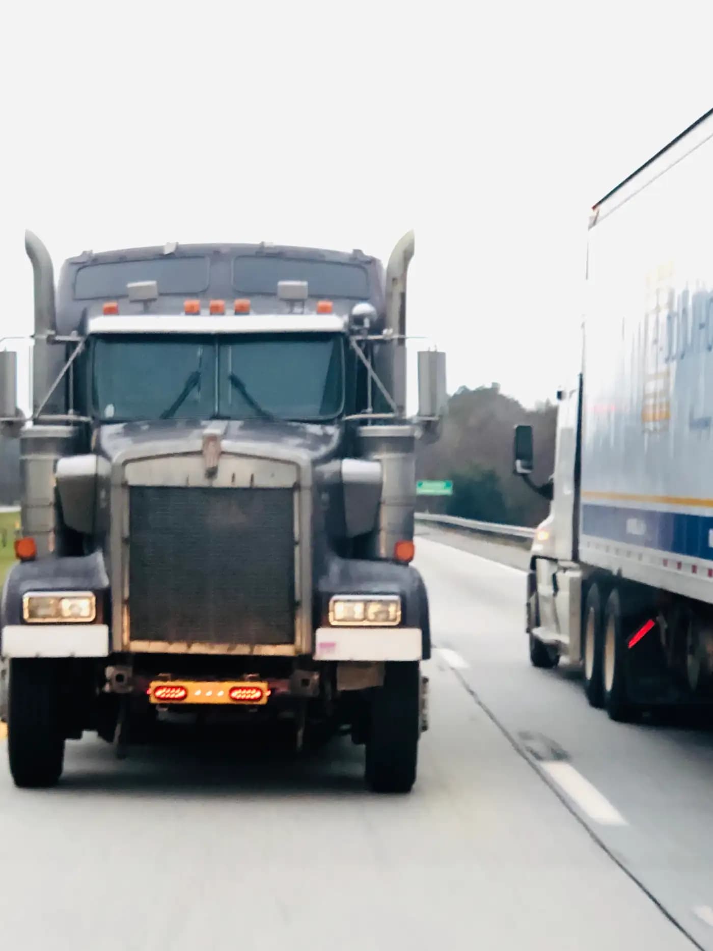 Semi-trucks traveling side by side