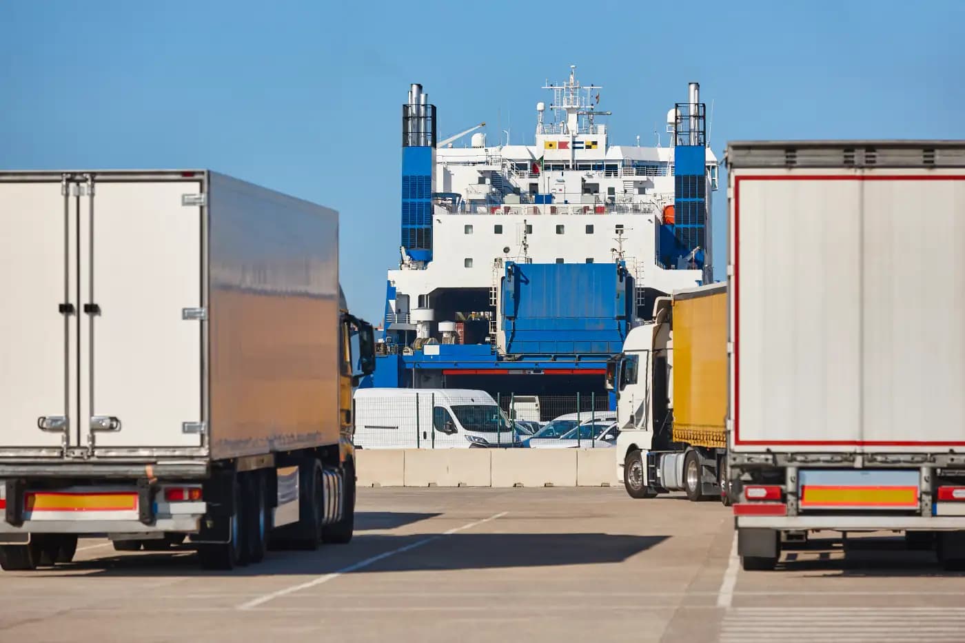 Trucks waiting near a cargo ship at a port
