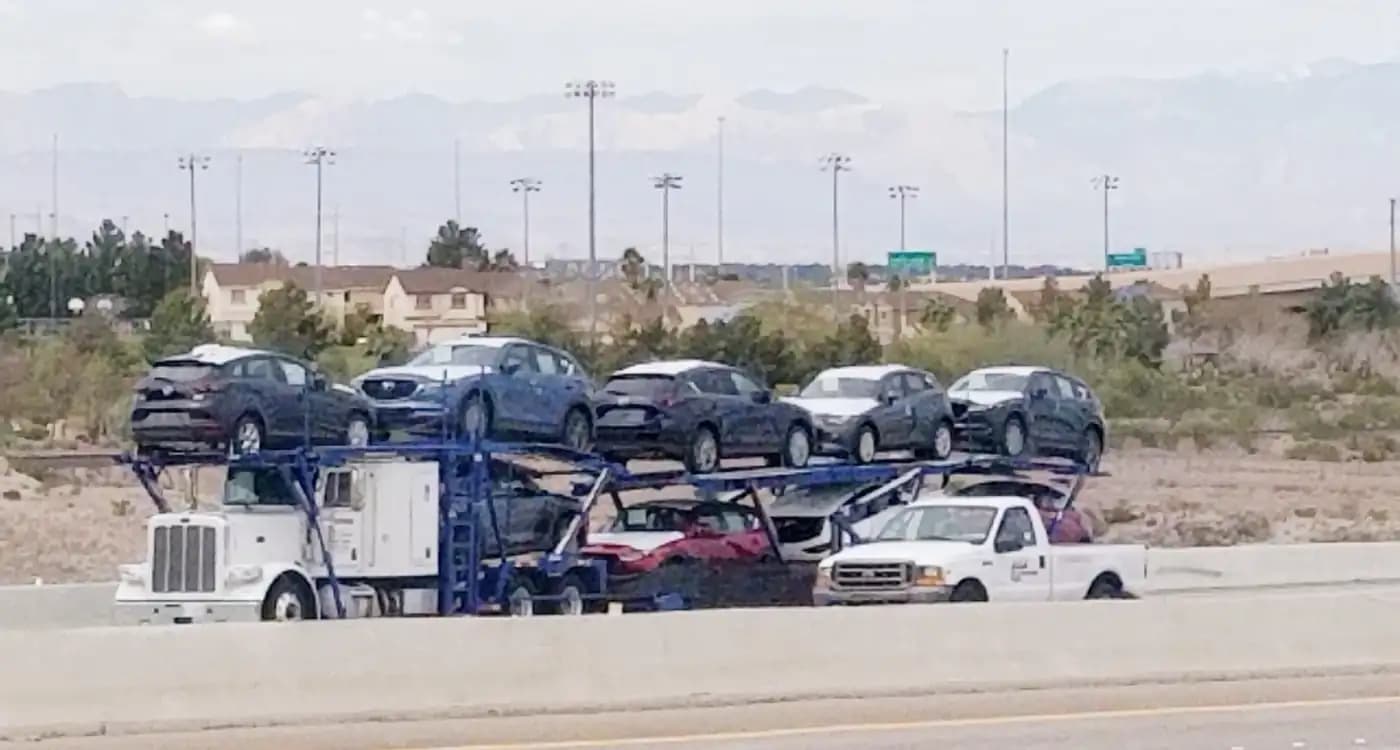 Loaded open car carrier passing through a desert landscape