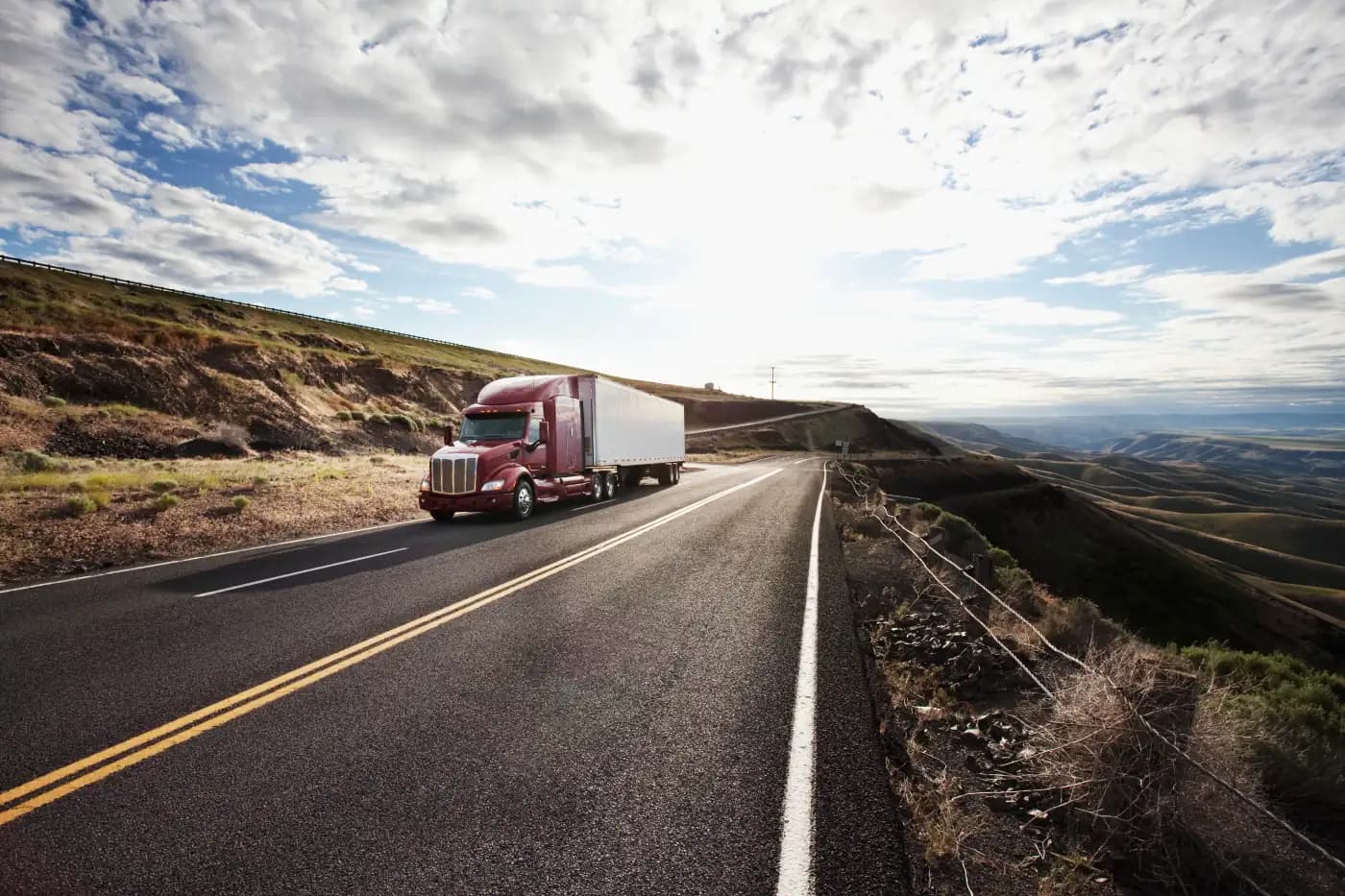 Tractor-trailer traveling through rolling hills