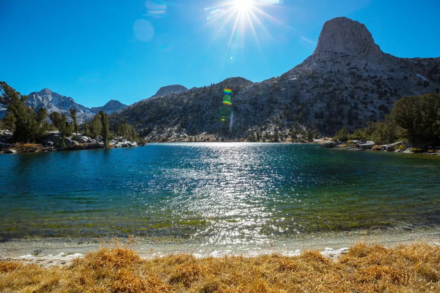 Blue alpine lake beneath a rocky mountain peak