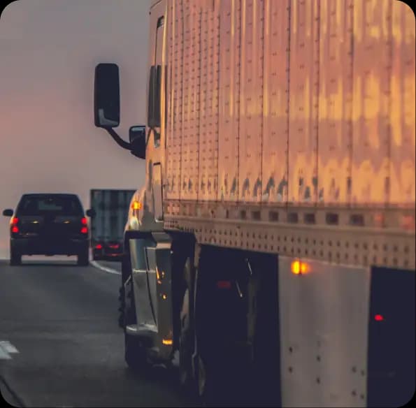 Tractor-trailer traveling in traffic at dusk